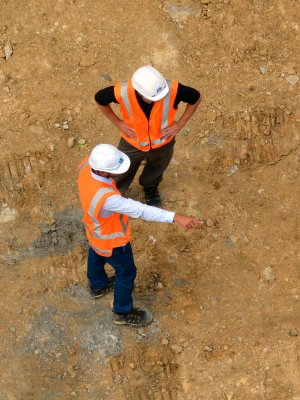 Engineers Standing on Dirt Pointing Discussing Project